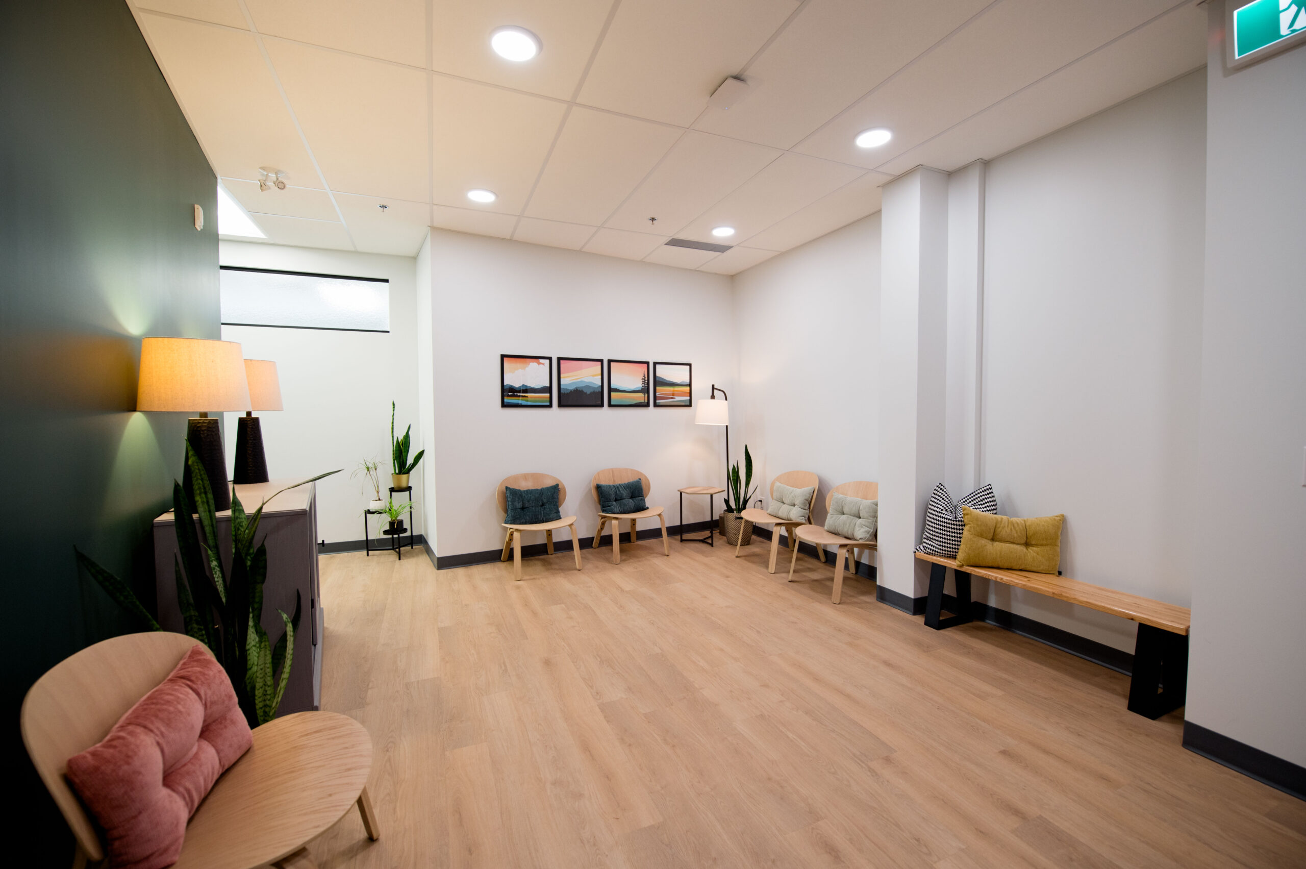 Spacious and cozy waiting area with chairs, plants, and modern lighting at Ross Psychology.